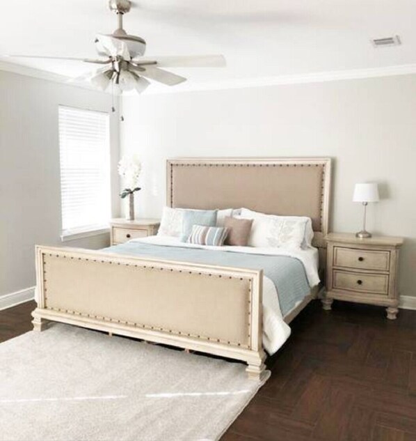 A bedroom with a bed, nightstands, a ceiling fan, and a window with blinds. - The Spacious Stay in a Tranquil Cul-de-Sac (Pensacola)