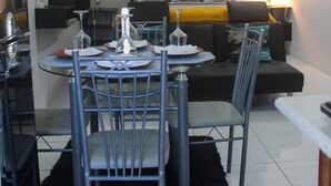 A dining area with a round table, chairs, and a ceiling fan. - Serenity's Condo 2 Bedroom Apartment (Montego Bay)