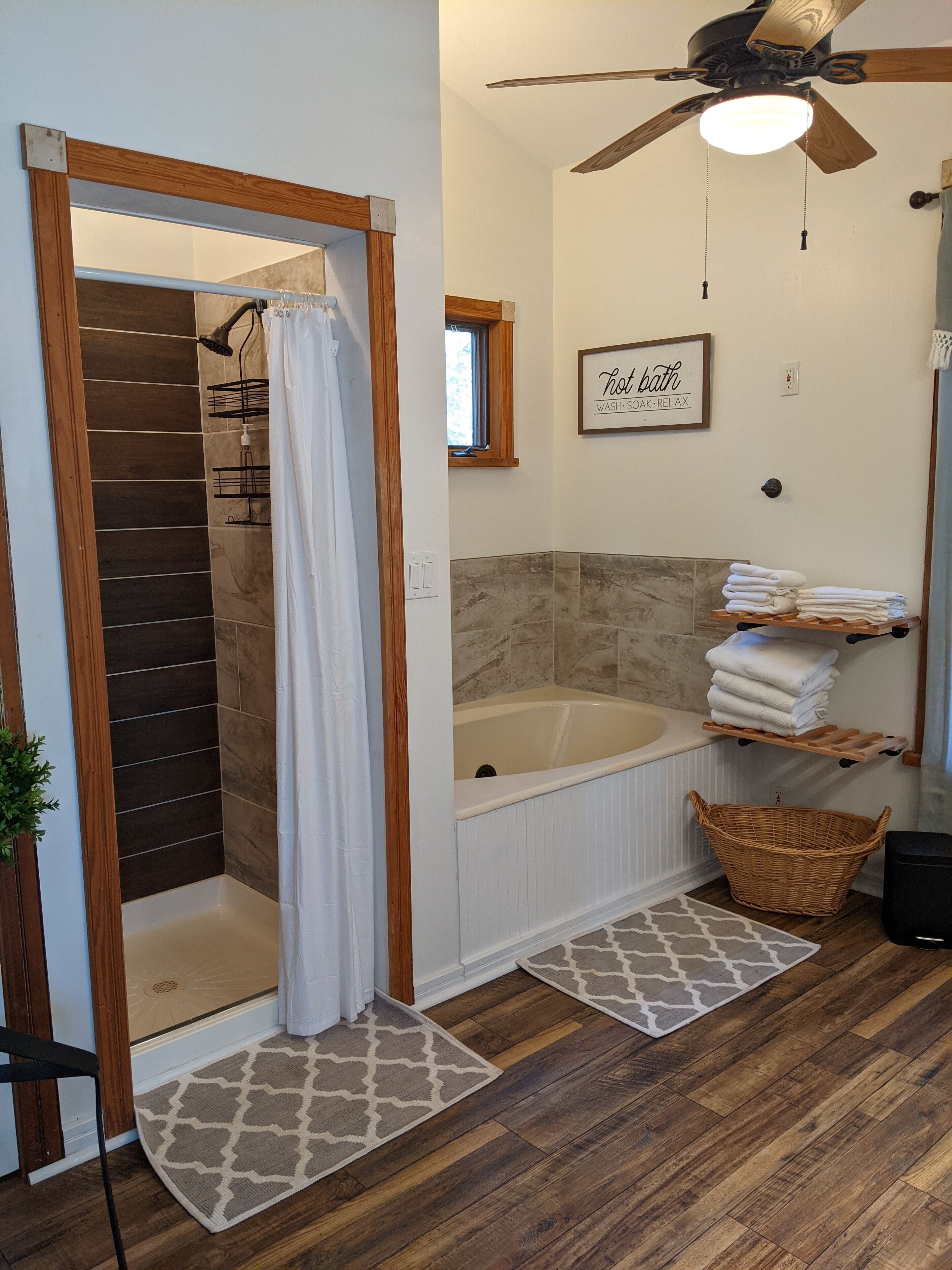 Un bagno con doccia, vasca, ventilatore a soffitto e porta asciugamani.
