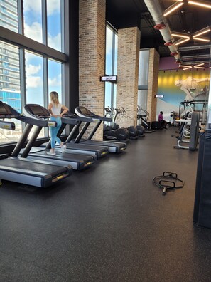 A gym with treadmills, a wall mural, and a sign indicating workout areas. - Lovely condo studio/High floor/ close to everythin/ roof top pool (Miami)
