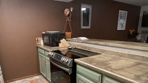 A kitchen with a large island, a built-in oven, and a microwave.