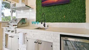 A modern kitchen with a green wall, a large TV, and a stainless steel range hood. - LUXURY Villa ALEXA Naples

Modern Voice controlled Villa with SALT WATER POOL (Naples)