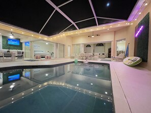 A modern indoor pool area with a glass enclosure, seating by the pool, and a television screen. - LUXURY Villa ALEXA Naples

Modern Voice controlled Villa with SALT WATER POOL (Naples)