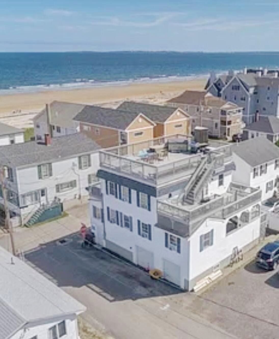 Zona residencial costera con casas y una playa al fondo.