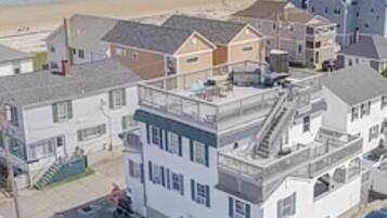 Zona residencial costera con casas y una playa al fondo.