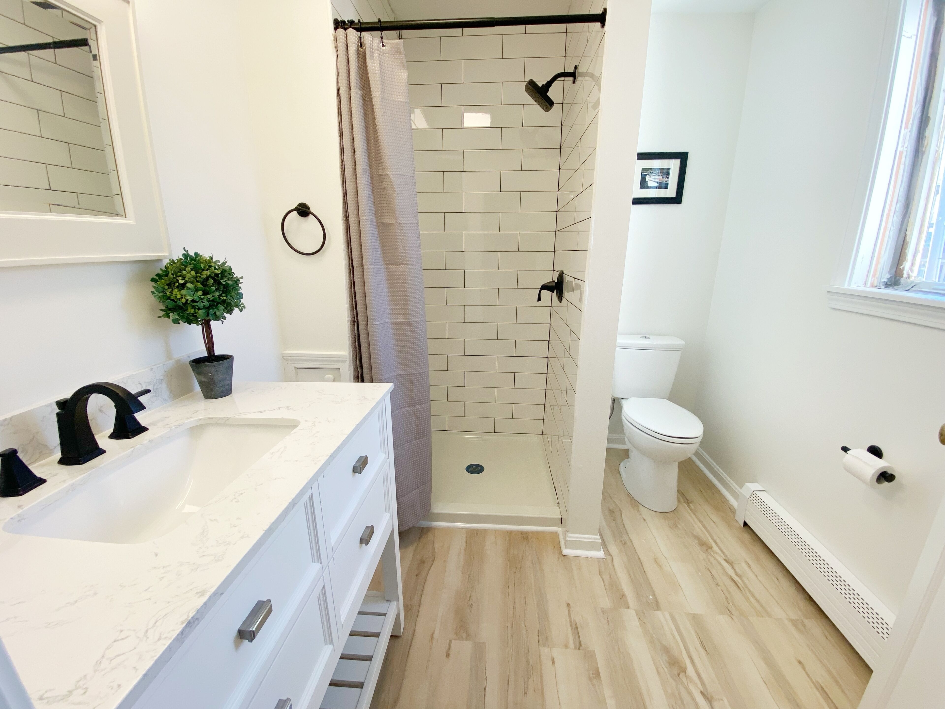 Une salle de bain avec douche, toilettes et lavabo.