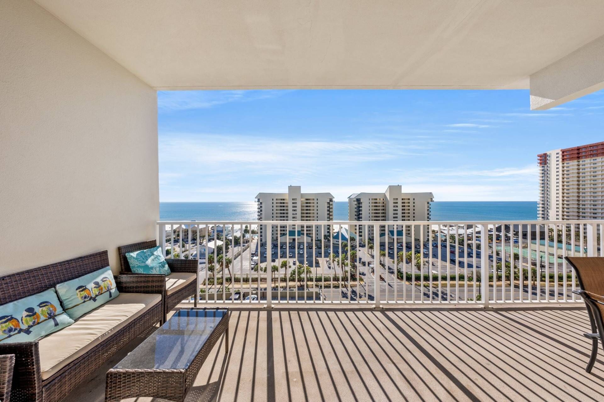A balcony with a view of the ocean and buildings.