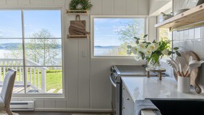 A kitchen with a view of a deck and a large window.