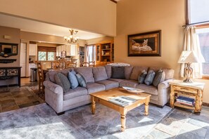 A cozy living room with a sectional sofa, a wooden coffee table, and a bookshelf. - Sunrise 9 (Mammoth Lakes)