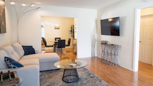 A modern living room with a sofa, coffee table, and TV. - NORTH HOLLYWOOD GEM: 2BR HOME w/ PRIVATE HOT TUB, PATIO/YARD & EV CHARGER p42 (Los Angeles)