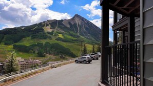 A mountain view with a building and parked cars. - Eagle's Nest, hot tub, great views (Mt. Crested Butte)