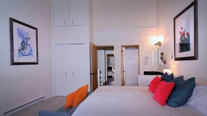 A bedroom with a bed, pillows, a chair, a desk, and framed artwork on the walls. - Eagle's Nest, hot tub, great views (Mt. Crested Butte)