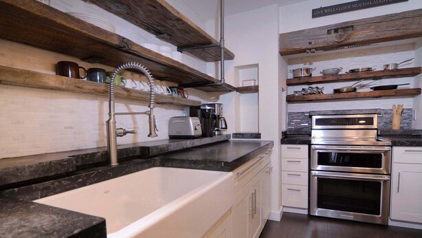 A kitchen with a built-in sink, stainless steel appliances, wooden shelves, and a sign encouraging positivity. - Eagle's Nest, hot tub, great views (Mt. Crested Butte)