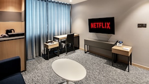 Una habitación de hotel moderna con escritorio, silla y televisor que muestra el logotipo de Netflix.