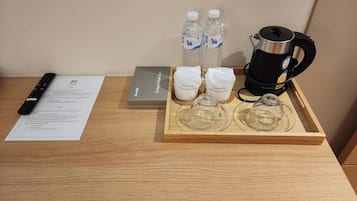 Un safata de fusta amb una cafetera, dues amples d'aigua i dues bosses esterilitzades damunt d'una taula.