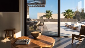 Una sala moderna con un amplio ventanal que da a un patio exterior.