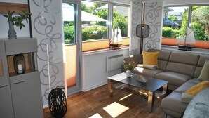 A modern living room with a sofa, a coffee table, and a fireplace. - Holiday house Schlenker (Binz)