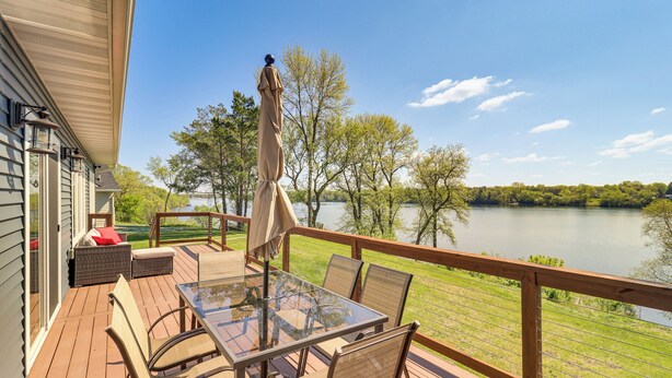 A deck with a glass table and chairs, overlooking a lake. - Spacious 6BR Lake Victoria Retreat w/ Private Dock (Alexandria)