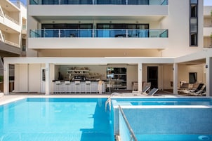 Un hotel moderno con piscina, zona de bar y comedor.