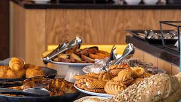 Een buffet met diverse broden en gebak.