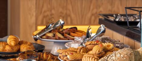 A buffet with various breads and pastries.