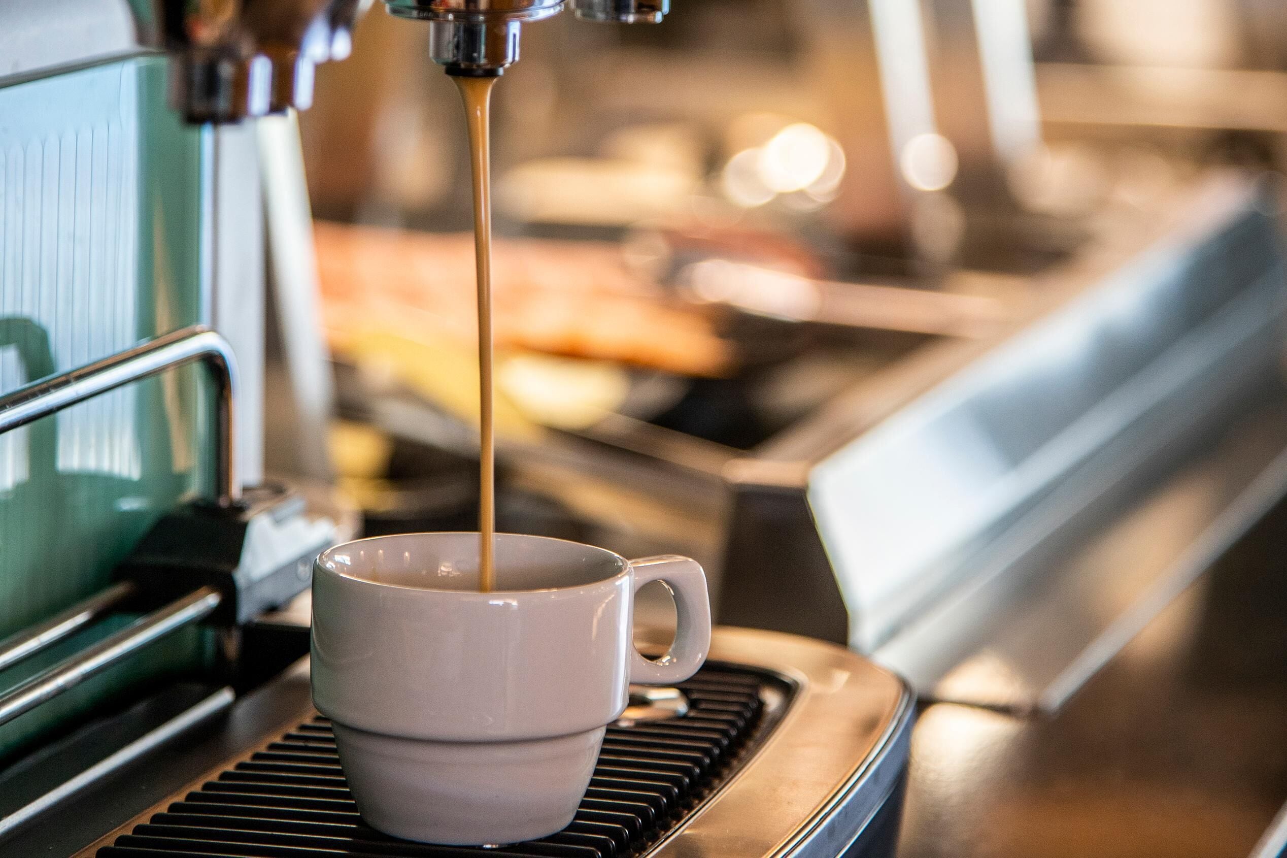 A coffee machine dispensing coffee into a cup.