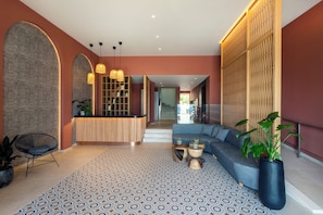 A modern lobby with a reception desk, seating area, patterned floor, and decorative lighting. - Kosea Boutique Hotel (Kos)