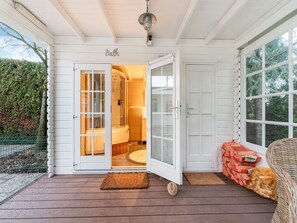bathroom entrance with a toilet, sink, and natural ambiance.