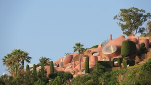 Una estructura arquitectónica singular con formas redondeadas, orgánicas y ventanas circulares.