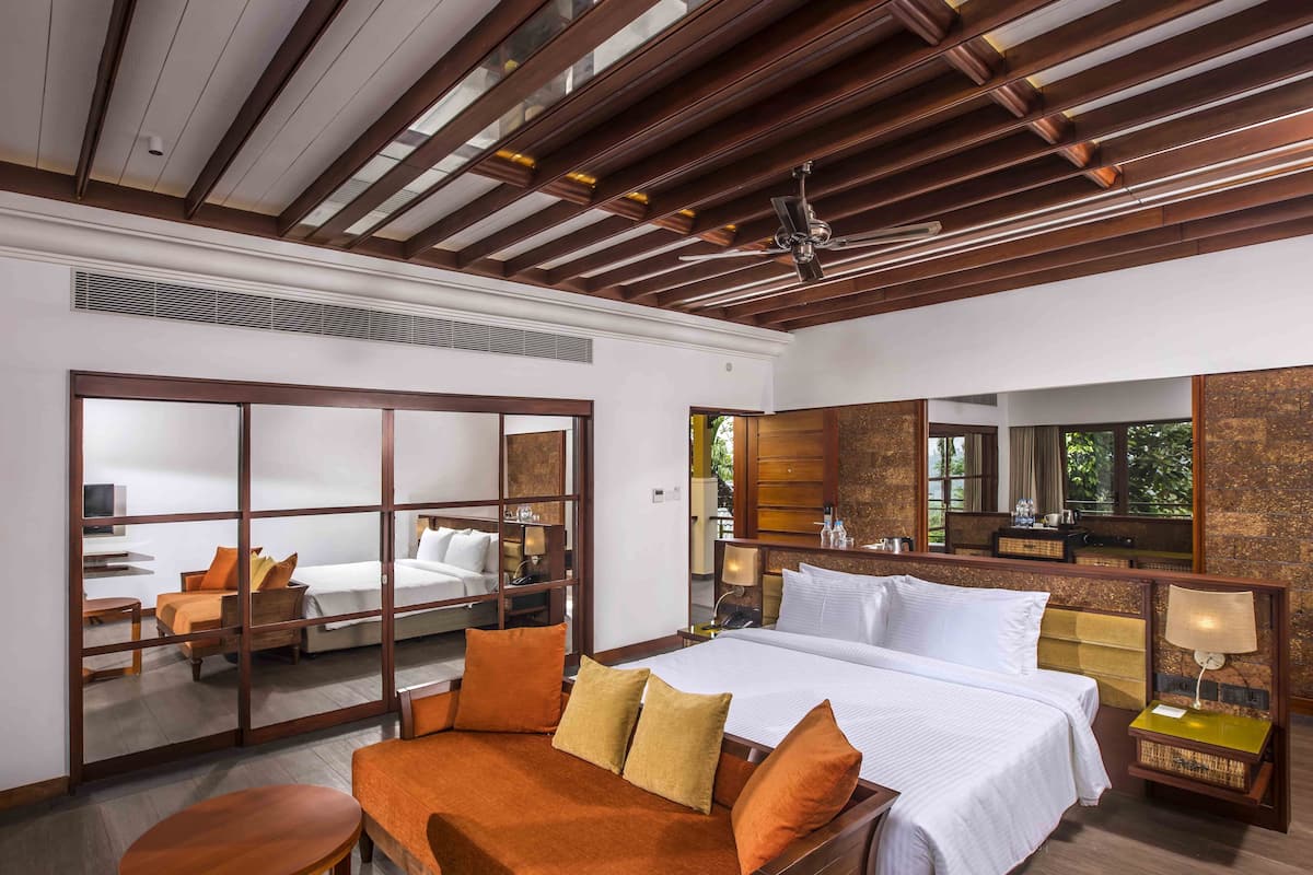Une chambre d’hôtel avec un grand lit, un canapé, un bureau et un miroir.