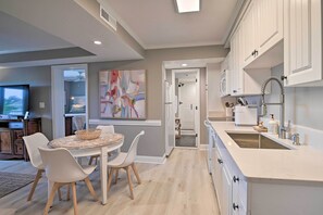 Enjoy meals in the central island kitchen with a dining table and chairs, flat-screen TV, and a large window.