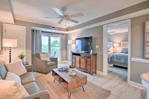 Relax in this inviting living room with a sofa, armchairs, and a TV.