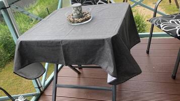 Ein Tisch mit grauem Tischläufer, einer dekorativen Mitte und gestreiften Kissen auf den Stühlen.