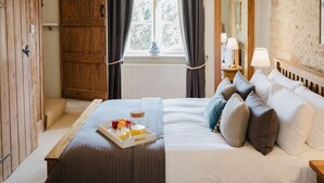 Une chambre à coucher avec un lit, une table de chevet et un plateau contenant des fruits et du jus.