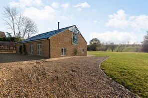 Une maison en briques avec un toit en pente et une allée gravillonnée.