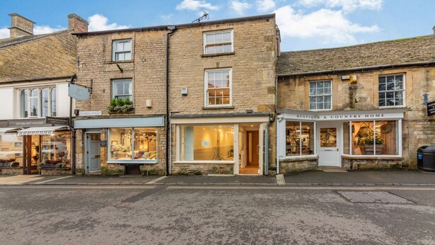 A row of traditional stone buildings with shops on the ground floor, including a flower shop and a home decor store. - Stylish two bedroom family friendly holiday Apartment in Stow-on-the-Wold - Church View Apartment (Cheltenham)