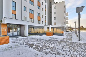 Ein modernes, mehrgeschossiges Gebäude mit flacher Fassade, großen Fenstern und Holzelementen.