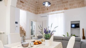 A cozy living room with a checkered tablecloth, a potted plant, and a grey sofa. - Charming apartment on several levels, located in a renovated period building, of which it retains fascinating evidence in the internal architecture. The flat is ideally located, outside the ZTL but a few steps from the historic center of Ostuni, in an ar (Ostuni)