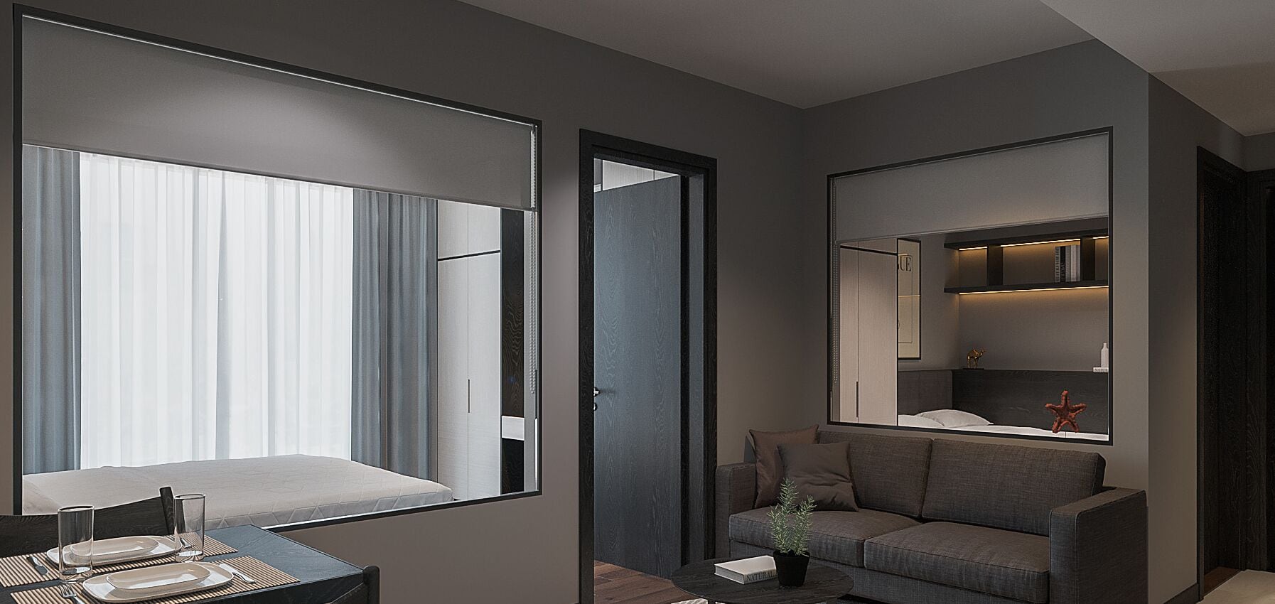 A modern hotel room with a large window, a sofa, a small table, and a mirror reflecting the room.