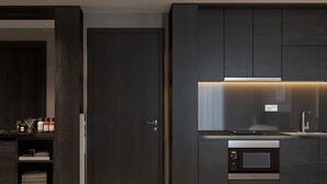 A modern kitchen with dark wood cabinetry, a built-in microwave, and a stainless steel sink.