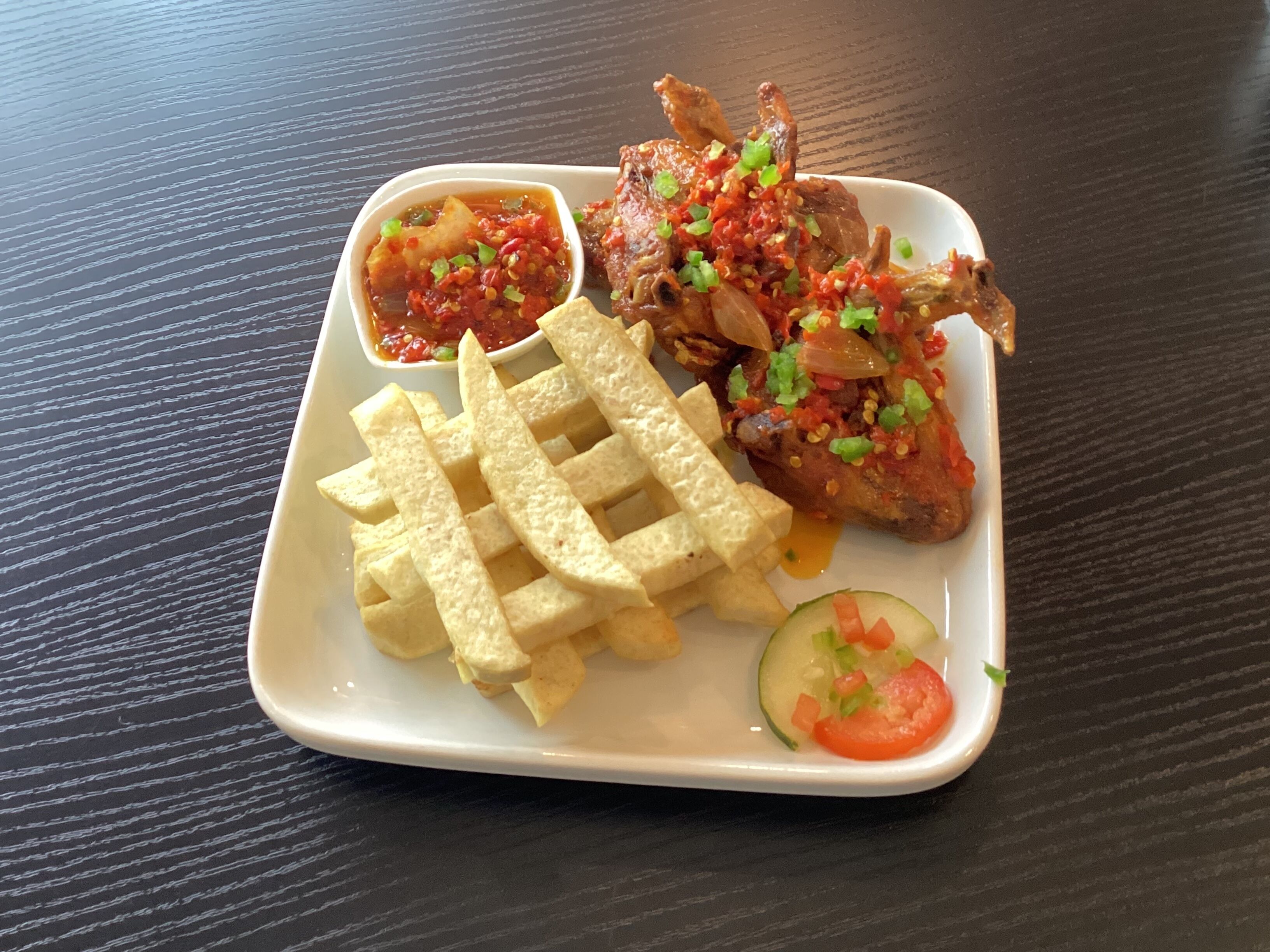 A plate with fried chicken, French fries, and a side salad.