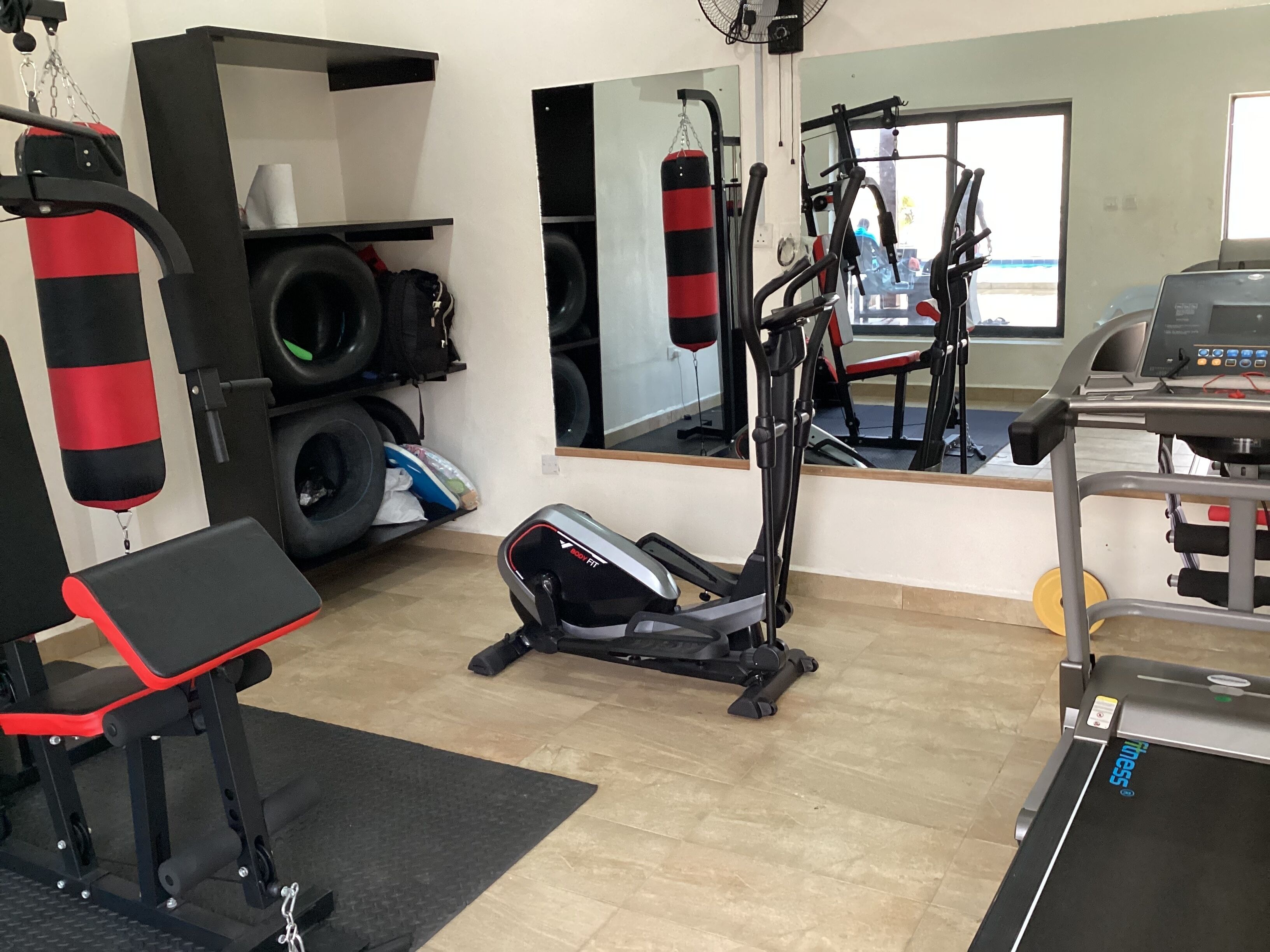 A gym with cardio machines, a punching bag, and a treadmill.