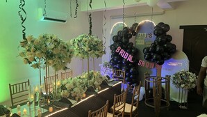 Una habitación con una larga mesa dispuesta para un evento nupcial, decorada con flores blancas y velas.