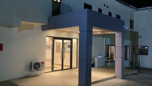 Un edificio moderno con acceso de vidrio y un área cubierta con un pilar.