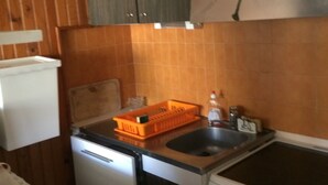 Une cuisine de taille réduite équipée d’un lave-vaisselle, d’une cuisinière et d’un évier.