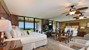 A spacious hotel room with a large bed, a dining area, and a view of the outdoors. - Remodeled, Ground floor studio at The Mahana #102 (Lahaina)