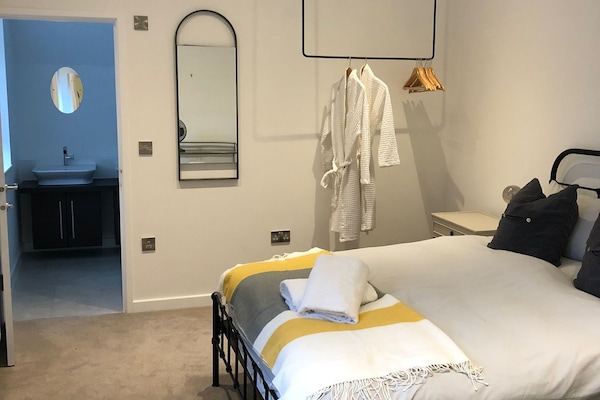 Large bedroom with 2 windows, en-suite bathroom, dressing gowns and hair drier.