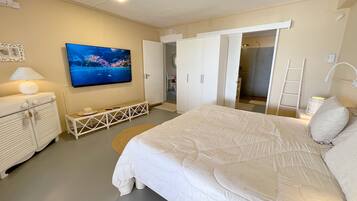 Una camera da letto con un letto, una televisione, un armadio e una ventola a soffitto.