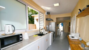 A modern kitchen with a microwave, sink, and stainless steel appliances. - Beachfront MEERENA, 2 bedroom cottage with Jacuzzi in Calodyne (Calodyne)