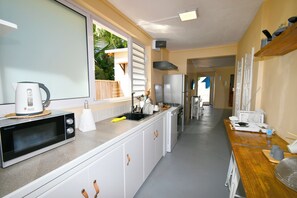 A modern kitchen with a microwave, sink, and stainless steel appliances. - Beachfront MEERENA, 2 bedroom cottage with Jacuzzi in Calodyne (Calodyne)